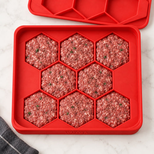 Overhead view of eight uniform hexagonal burger patties in the red WAFORA BurgerBatch tray.