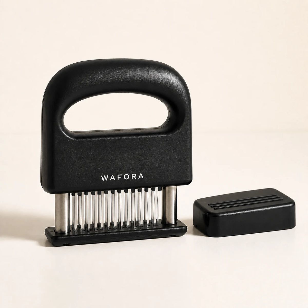 Black WAFORA TenderPress 48-blade meat tenderizer with protective cover on a warm ivory background