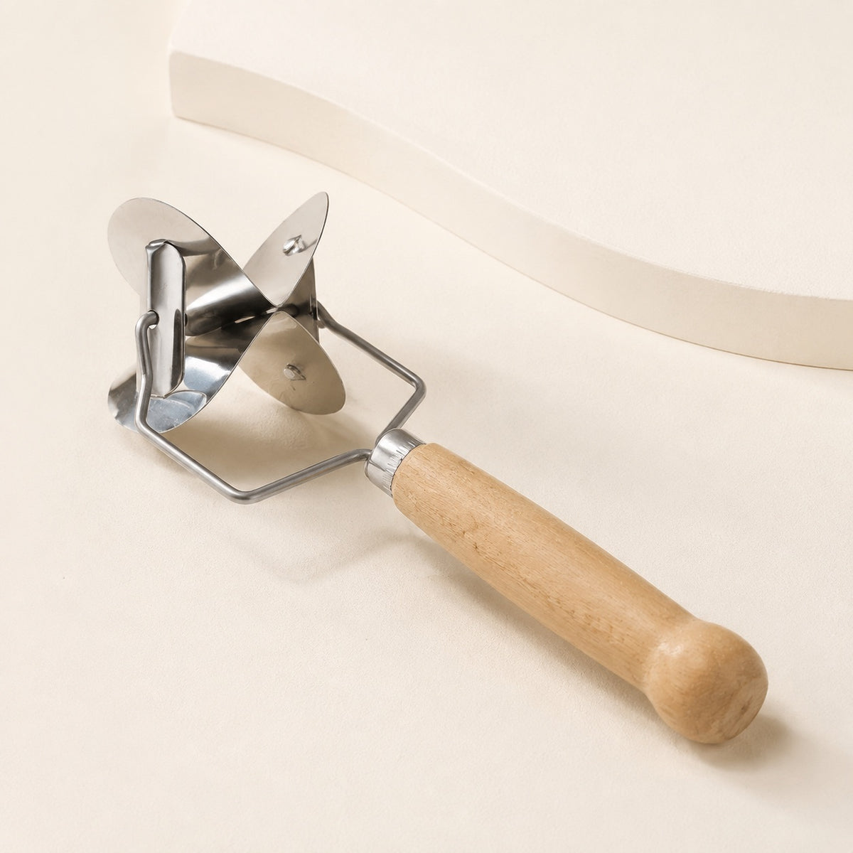 Close-up of the WAFORA manual pastry cutter with rotating metal cutting head and wood handle