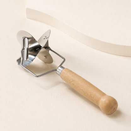 Close-up of the WAFORA manual pastry cutter with rotating metal cutting head and wood handle