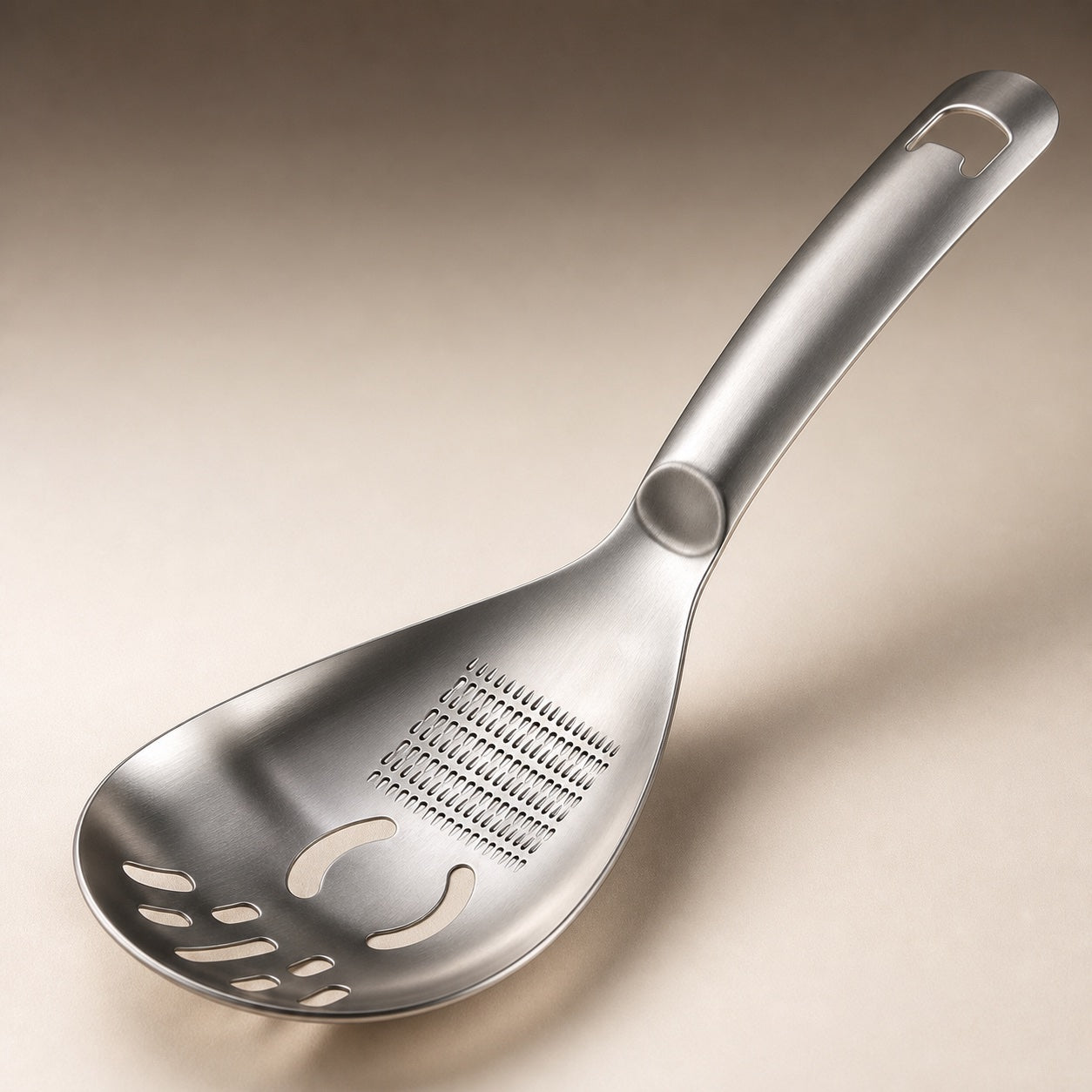 Close view of MashMate grater teeth, egg-separation openings, drainage slots and bottle opener
