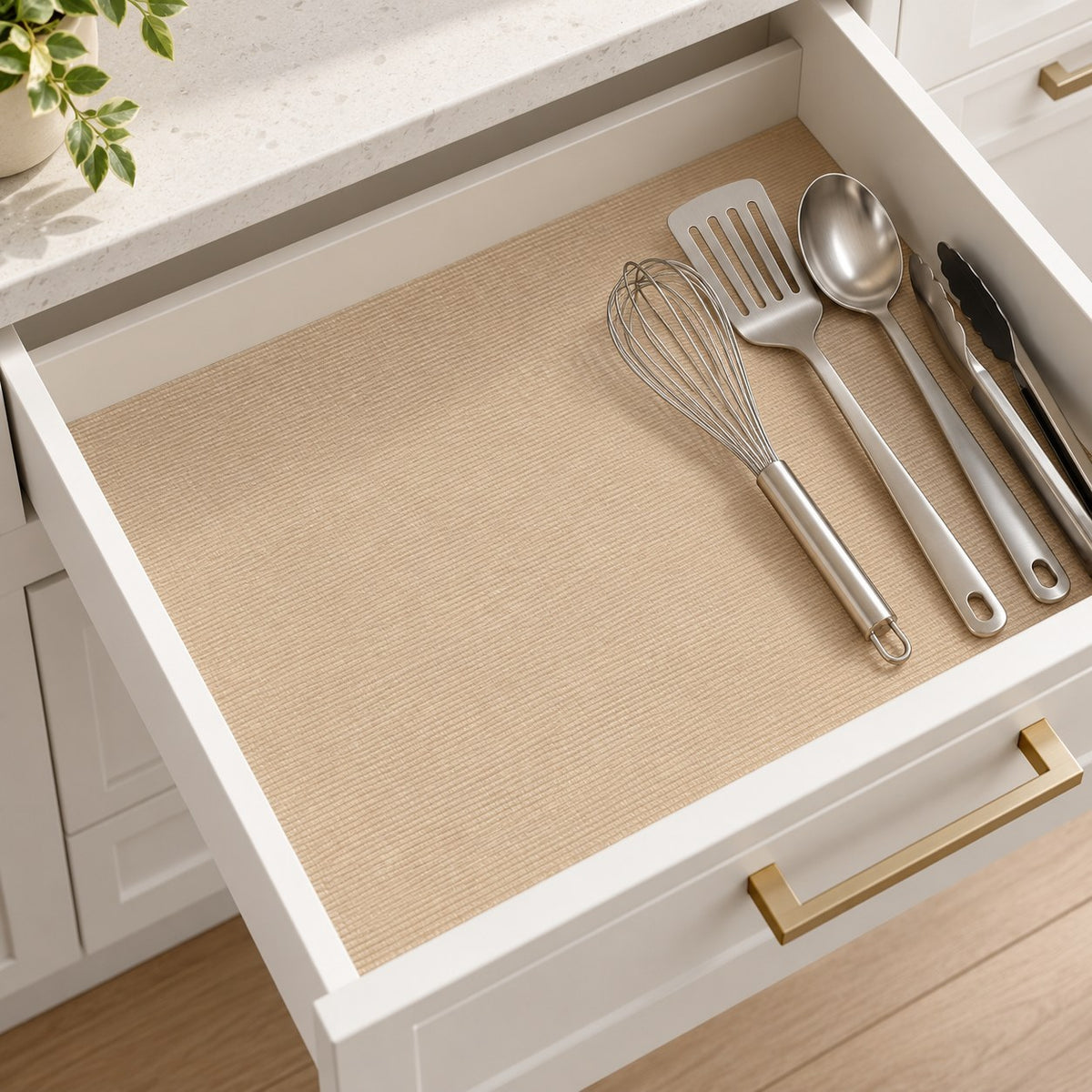 Khaki shelf and drawer liner fitted inside a white kitchen drawer beneath utensils